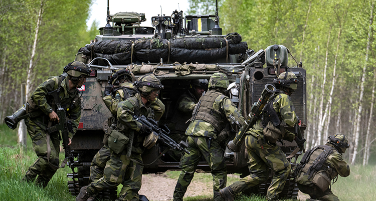 Svenska soldater övar vid en pansarvagn.