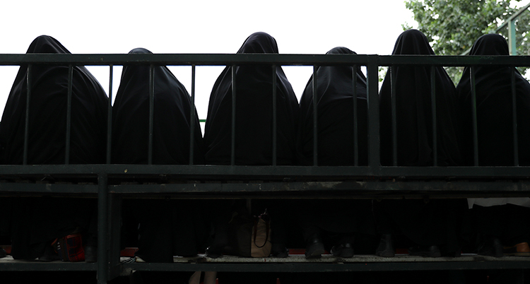 Siluhetter av kvinnor med helt täckande svarta slöjor.