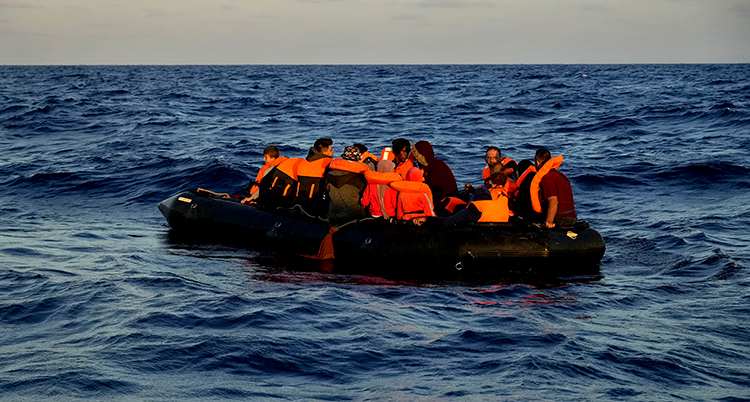 migranter i en båt.