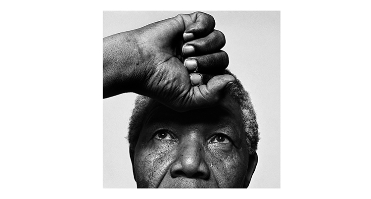 Mandela har sin knutna näve i pannan.