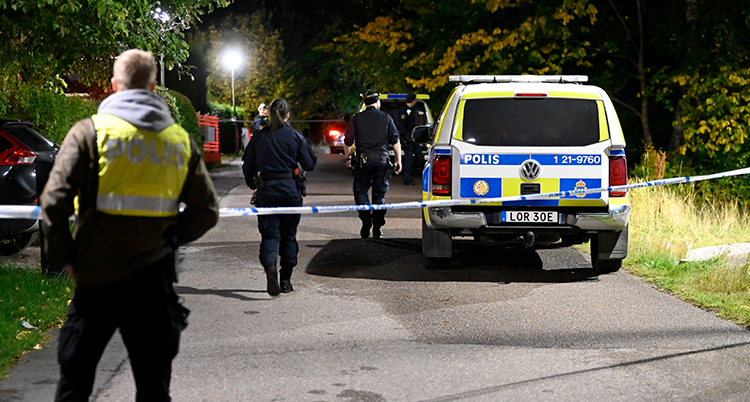 Poliser framför ett avspärrningsband i enköping.