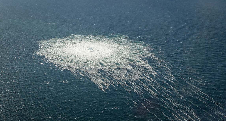 En bild som är tagen från luften, ner mot havet. Där bubblar det upp gas på ytan.