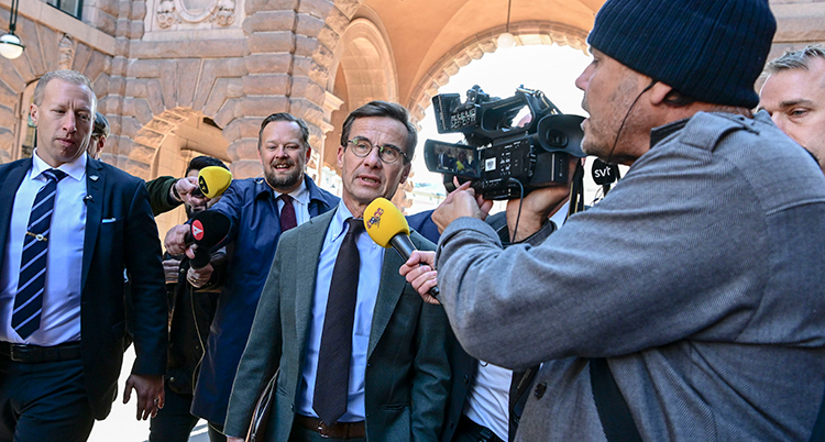 Kristersson med flera journalister och mikrofoner.