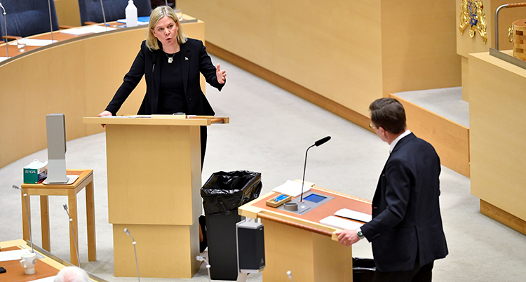 Andersson och Kristersson i varsin talarstol i riksdagen.