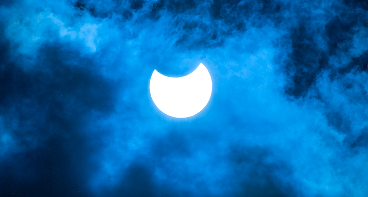 en bild på himlen och solen som är delvis täckt av månen.