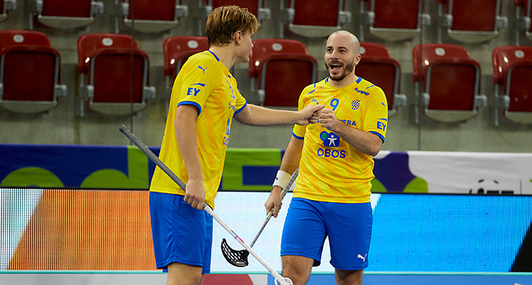 Två svenska spelare firar efter ett mål.