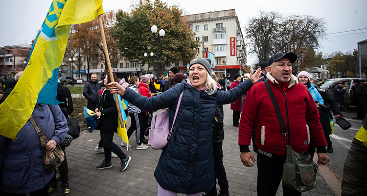 Människor med ukrainska flaggor har samlats ute på gatan.