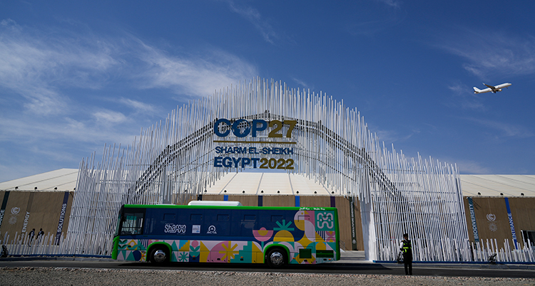 En buss står framför en stor hall, dekorerad med en stor silverportal.