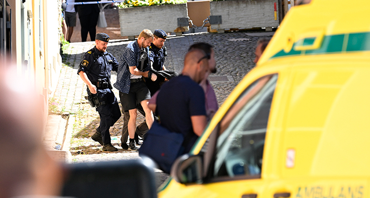 Poliser ses hålla fast någon på en gata i Visby. Bilden är rörig, mannen syns knappt. En ambulans syns i förgrunden av bilden.