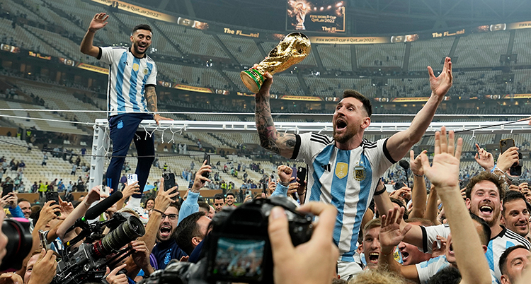 Argentinas spelare firar segern. Spelaren Lionel Messi är i mitten och håller bucklan.