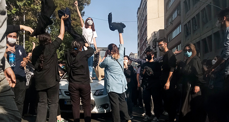 Människor på en gata sträcker upp armarna.
