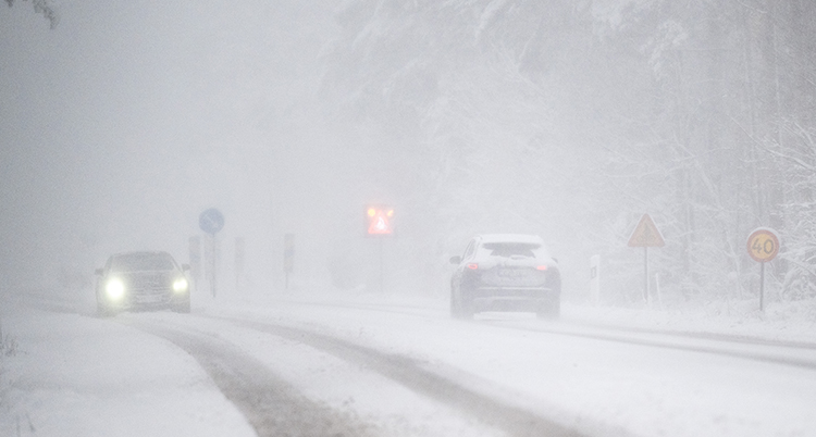 bilar kör på en snöig väg.