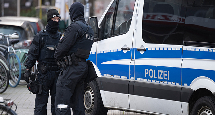 Poliser i Tyskland vid en polisbil.