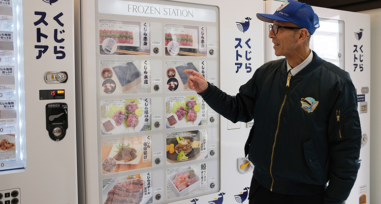 En man står vid en vit automat med olika skyltar med maträtter på