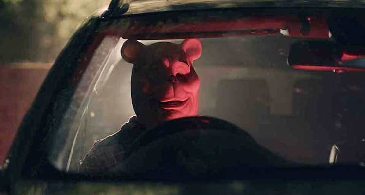 En person med en Nalle Puh-mask sitter i en bil.