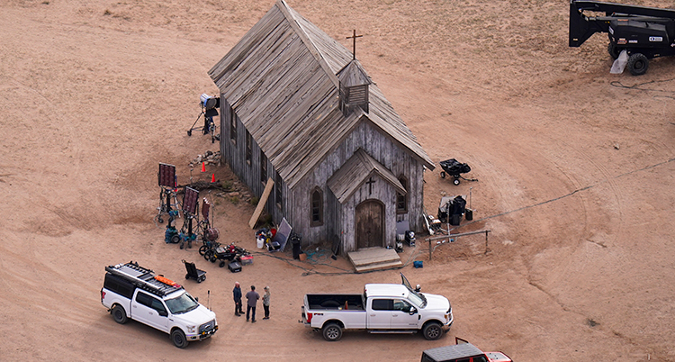 En bild tagen uppifrån. En träkyrka i ett ödelandskap med sand. Några bilar utanför kyrkan.