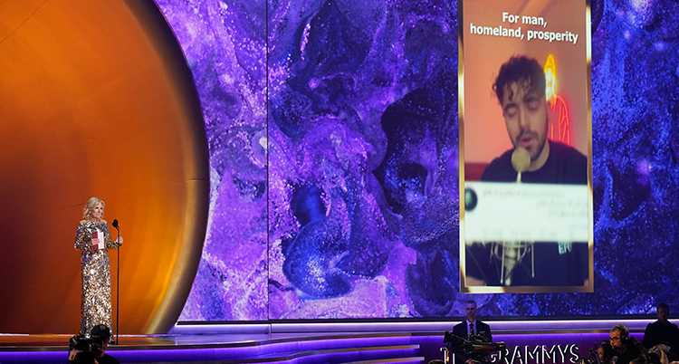 Bild från scenen när Jill Biden pratar om priset, till höger syns en film som visar när Shervin sjunger sin låt.