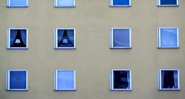 Många fönster i rader på en husvägg.