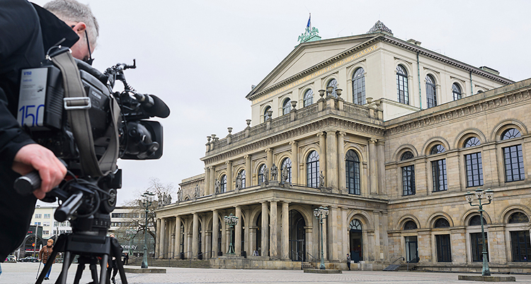 En man filmar utanför Operan i Hannover.