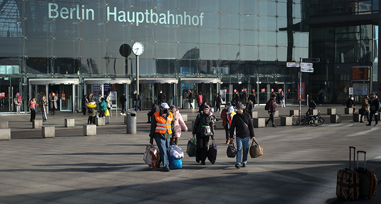 Människor med resväskor framför entrén till Berlins tågstation.