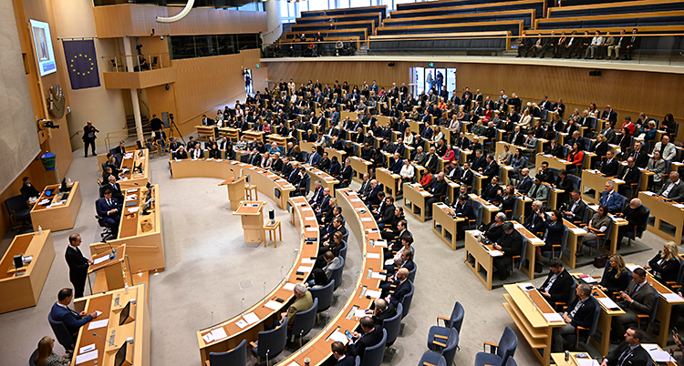 En stor sal med bord och stolar och flera hundra politiker.