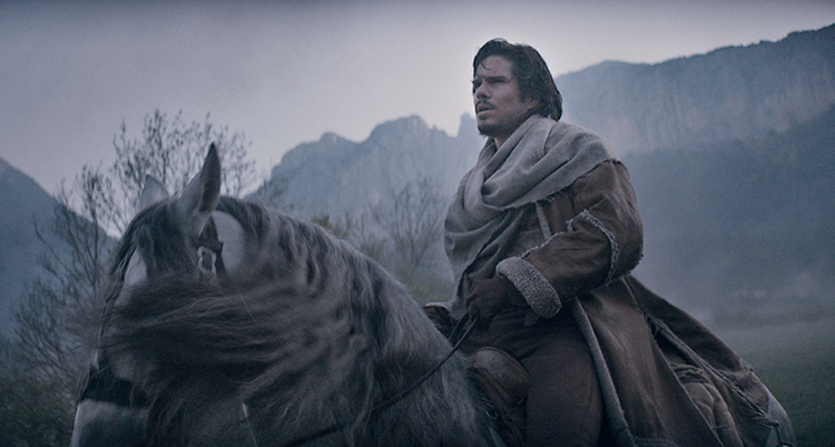 En man sitter på en häst i ett vackert landskap.