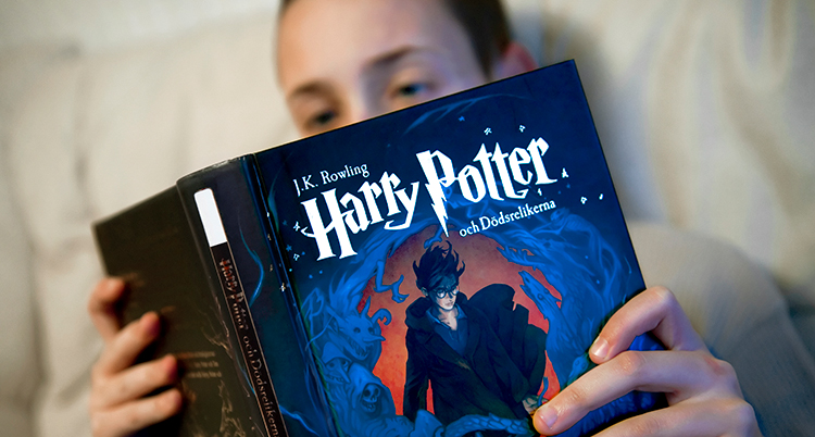 Ett barn läser en Harry Potter-bok.