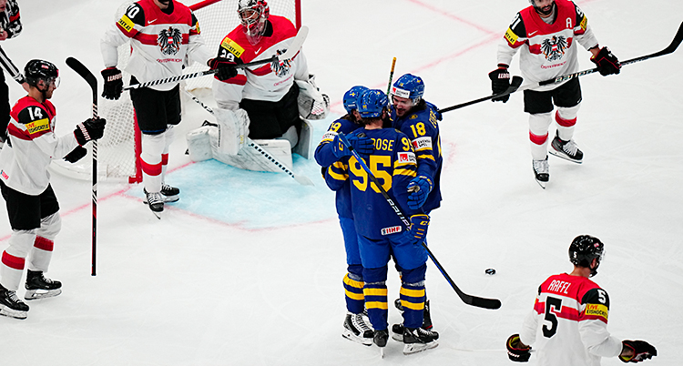 Några ishockeyspelare står på isen och kramas.