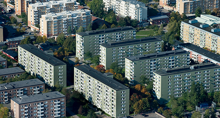 En flygbild som visar stora gröna hus med lägenheter.