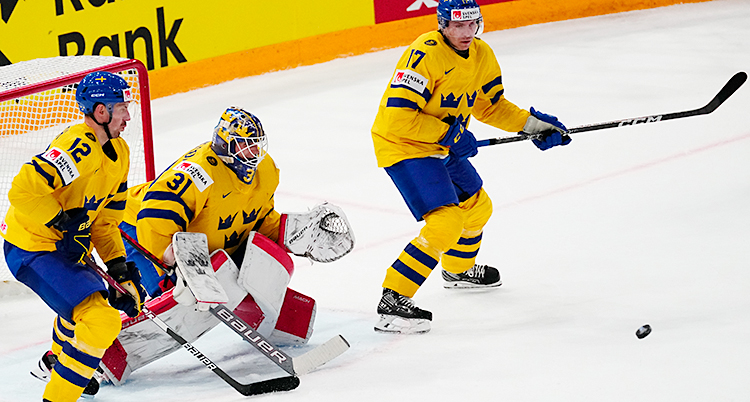 Från en match i ishockey. Bilden visar Sveriges målvakt och två andra spelare i Sveriges lag.