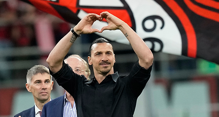 Zlatan är mitt på planen, i svart skjorta. Han gör ett hjärta med sina händer.
