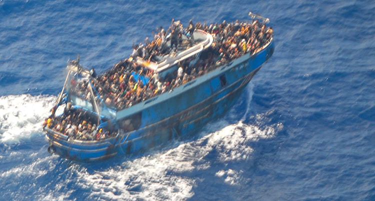En båt i havet. Båten är full av människor.
