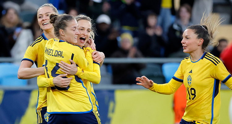Svenska fotbollsspelare jublar och kramar om varandra.
