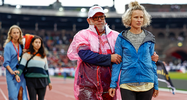 En man håller fast en kvinna på Stockholms stadion.