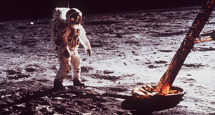 En astronaut står bredvid en månlandare på månen.
