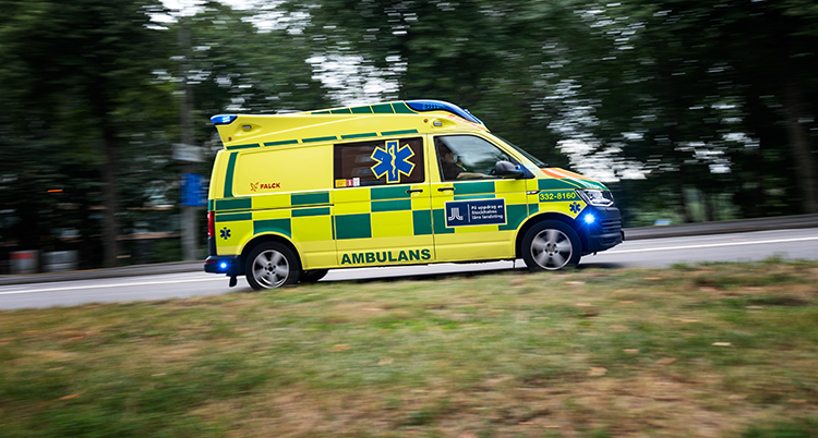 En ambulans åker på en väg.