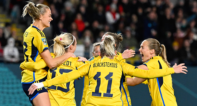 Glada svenska spelare kramar om varandra i en ring.