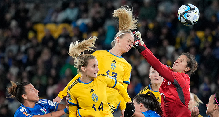 Spelaren nickar bollen framför en boxande italiensk målvakt.