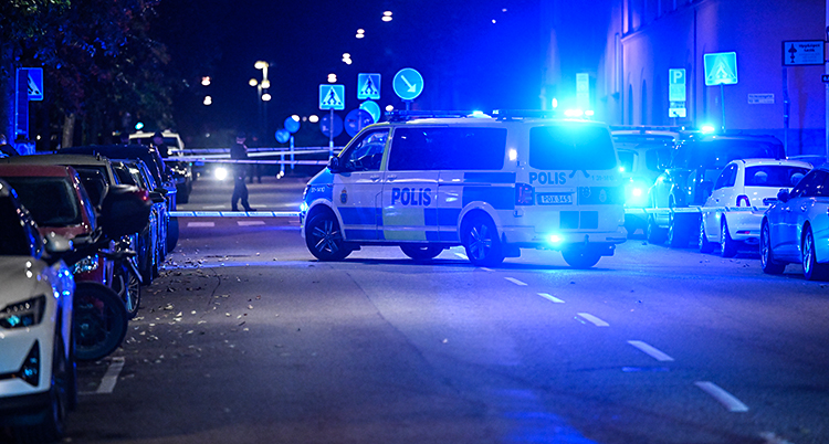 Det är mörkt ute. En polisbil står på en gata mitt i Stockholm.