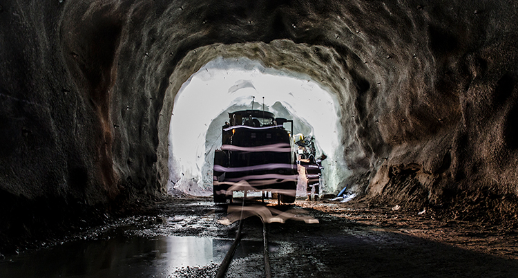 Under jord. En traktor kör genom en tunnel nere i en gruva.