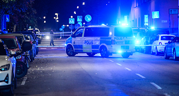 Det är mörkt ute. Poliserna har spärrat av en gata mitt i Stockholm.