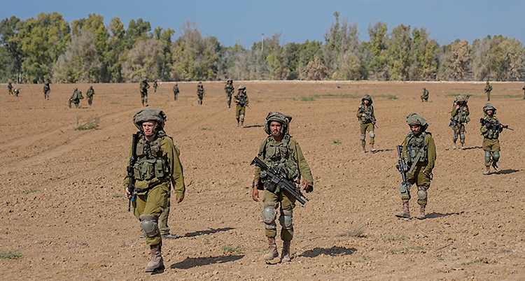 En grupp soldater går över ett dammigt fält.