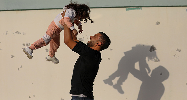 Yousef lyfter upp sin dotter.
