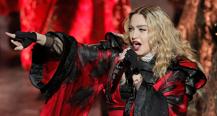 Madonna sjunger och sträcker ut ena armen.