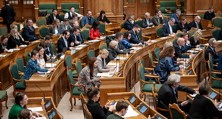 Många politiker sittet i en stor sal.