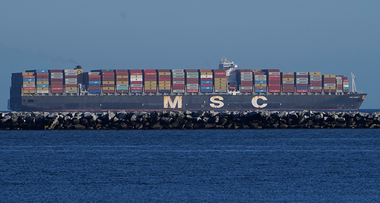 Ett stort fartyg med containrar kör i havet.
