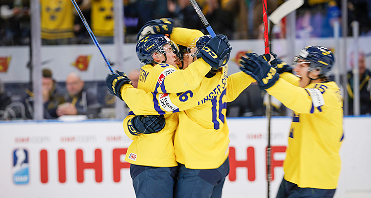 Från en match i ishockey. Tre svenska spelare kramas efter ett mål.