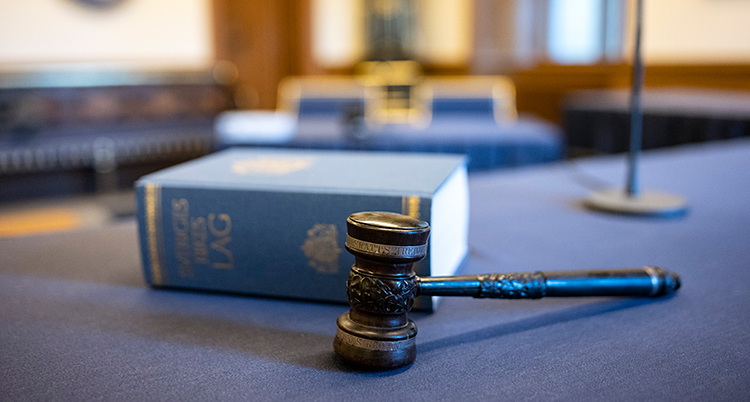 En klubba och en lagbok som ligger på ett bord i en domstol.