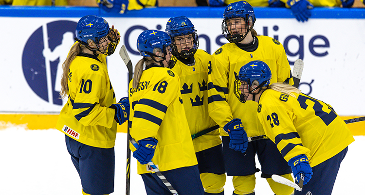 De står i en grupp. DE har gula ishockeytröjor och blå hjälmar.
