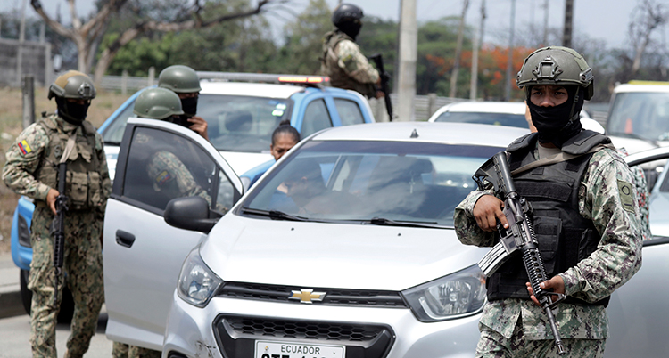 Militärer med vapen undersöker en bil.